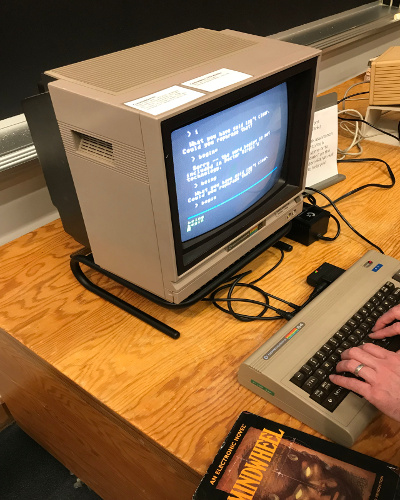 Person sits in front of a computer playing a classic IF game